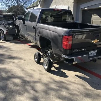 Chevy Silverado lifted on dollies in a driveway